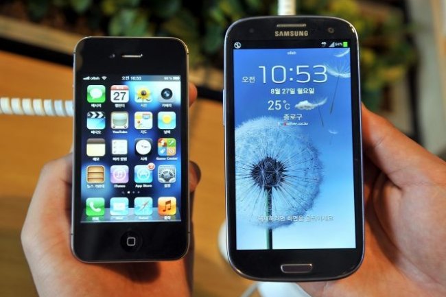 Le Samsung Galaxy S3 ( droite) s'est impos comme un srieux concurrent  l'iPhone, aussi bien technologiquement qu'en termes de ventes. AFP photo / Jung Yeon-Je